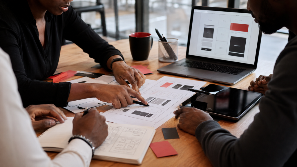 Black South African professionals planning a Starter Sprint with landing page wireframes, offer notes, and prototype strategy documents.